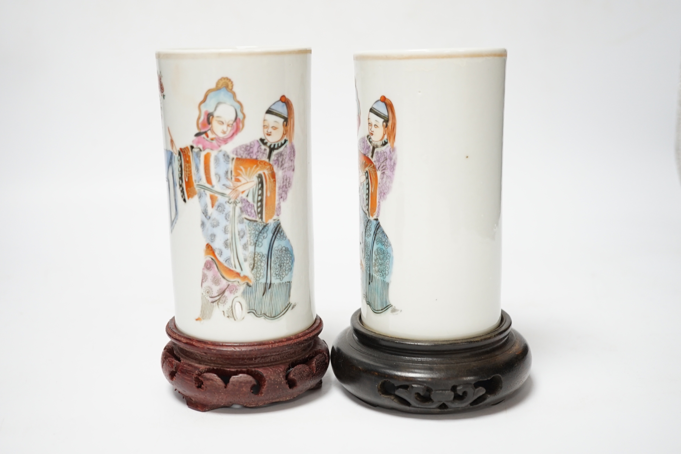 A pair of Chinese cylindrical famille rose brush pots on associated stands, largest 15cm high overall
